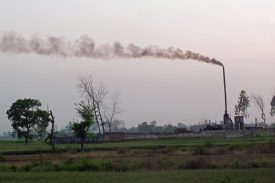 spewing smoke and .pollution into a green rural environment
