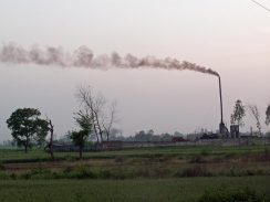spewing smoke and .pollution into a green rural environment