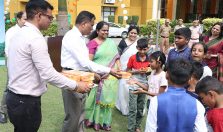 Shri G S Rajeswaran, the then Directorate General Defence Estates distributing sweets among the children on the occasion of 77th Independence Day;?>