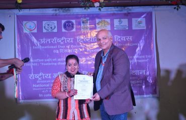 डॉ. ललित नारायण, निदेशक, रागदिसं, कोलकाता, दिव्यांग कलाकार को प्रमाण पत्र और पुरस्कार प्रदान करते हुए।