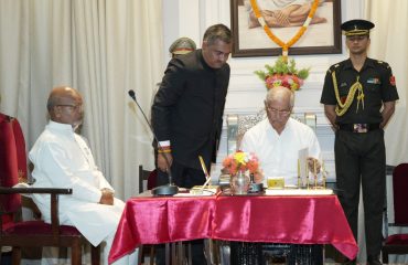 His Excellency signing the oath document.