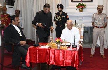 Honorable Governor signing the document after the oath.