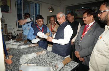 Honorable Governor observing the prosthetic limbs.