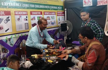 Dr.K.K, Dhanavendan, Special Teacher (CP) explaining the Assistive Devices of CP in CP experience Zone