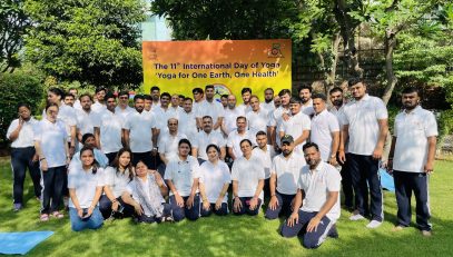 Group photograph of RCI officials during the 11th International Day of Yoga celebration with banner 'Yoga for One Earth, One Health' in the background.