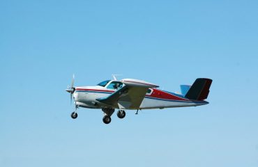 private airplane Beech Bonanza flying in blue sky