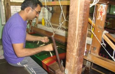 While weaving paithani, men