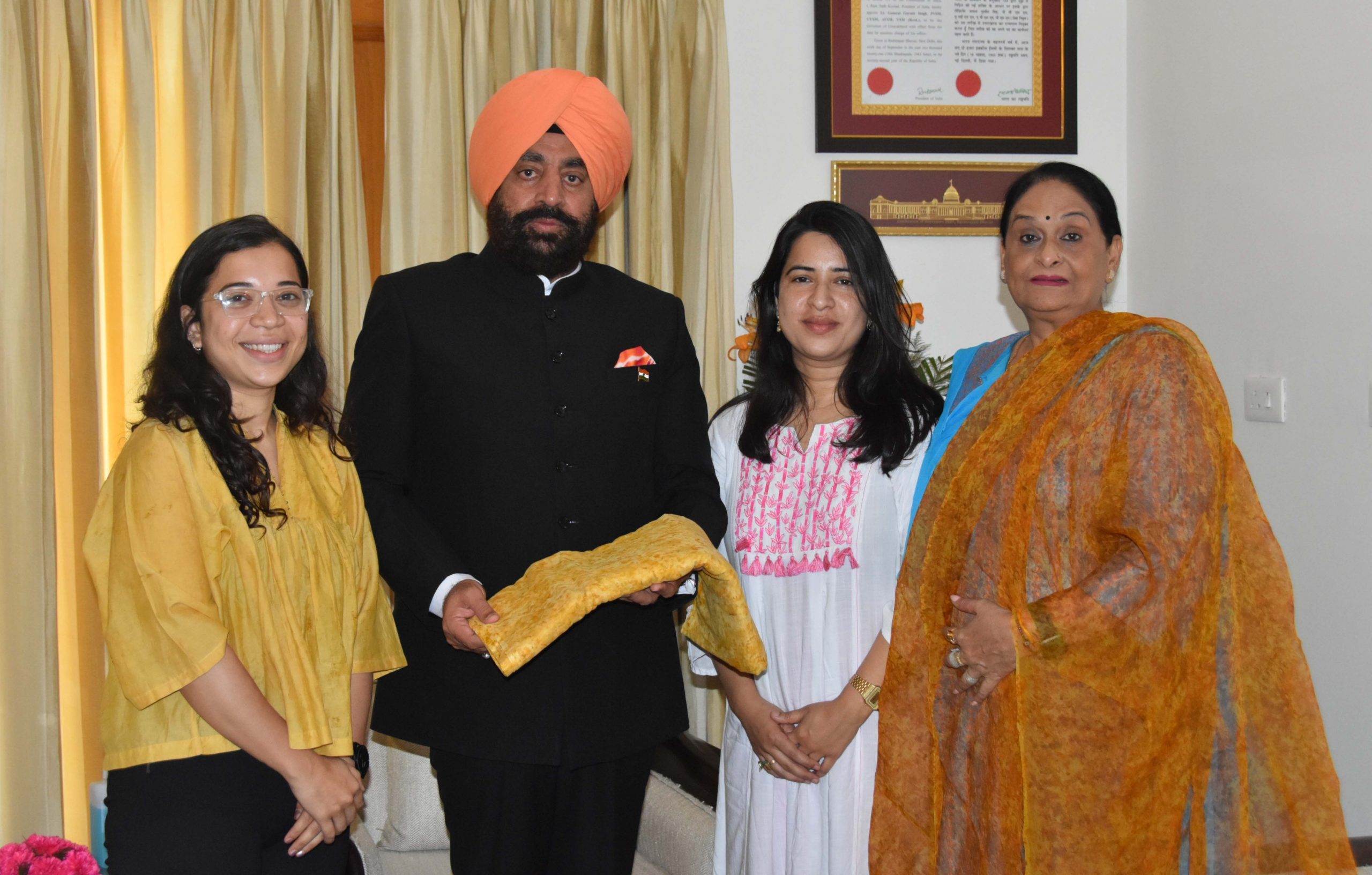 Alisha and Ankita Mandolia of 'Mulya' Association presenting a floral printed turban to Governor Lt Gen Gurmit Singh (Retd).