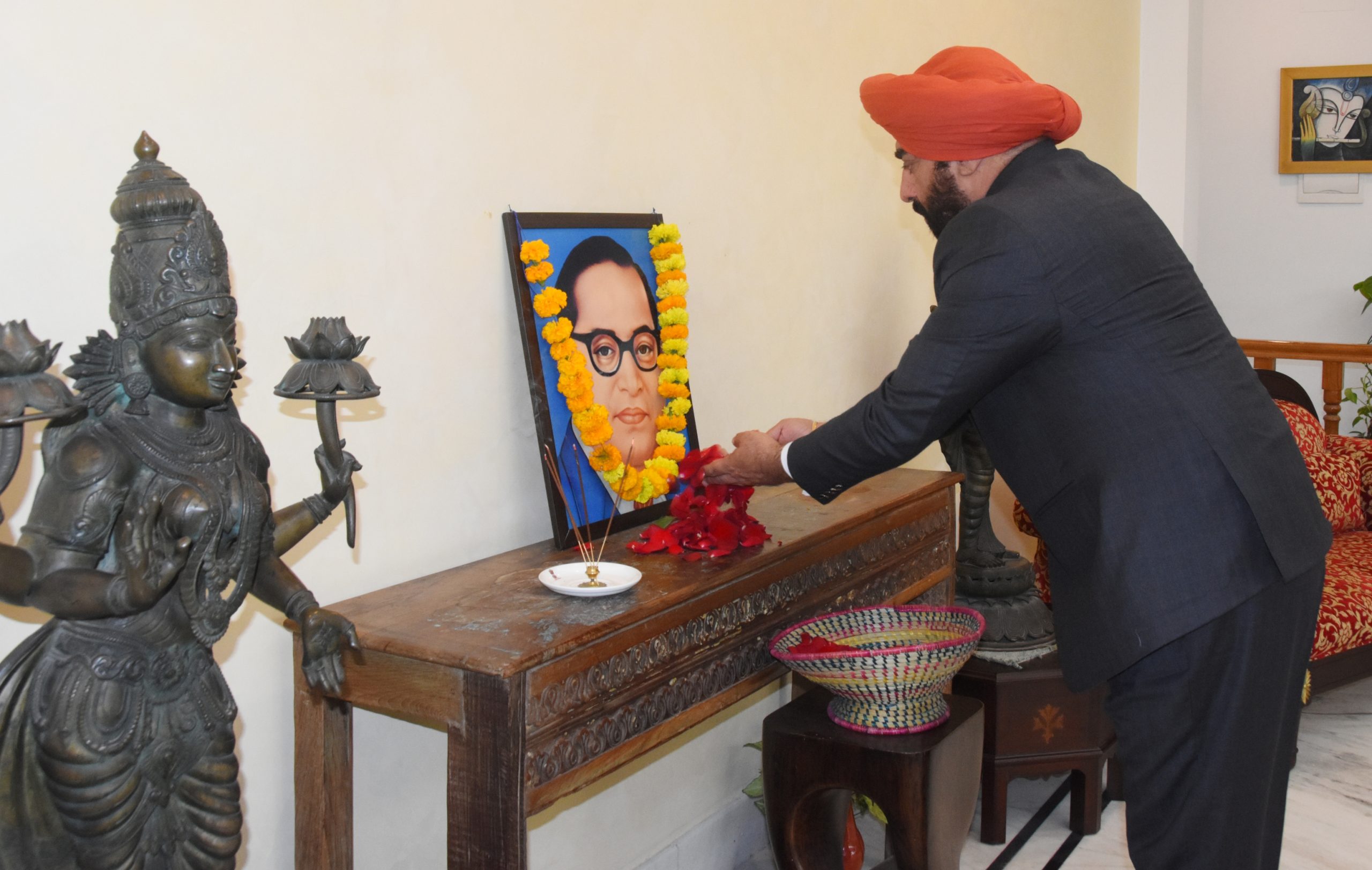 Governor paying tribute by offering flowers on the portrait of Bharat Ratna Babasaheb Dr. Bhimrao Ambedkar.