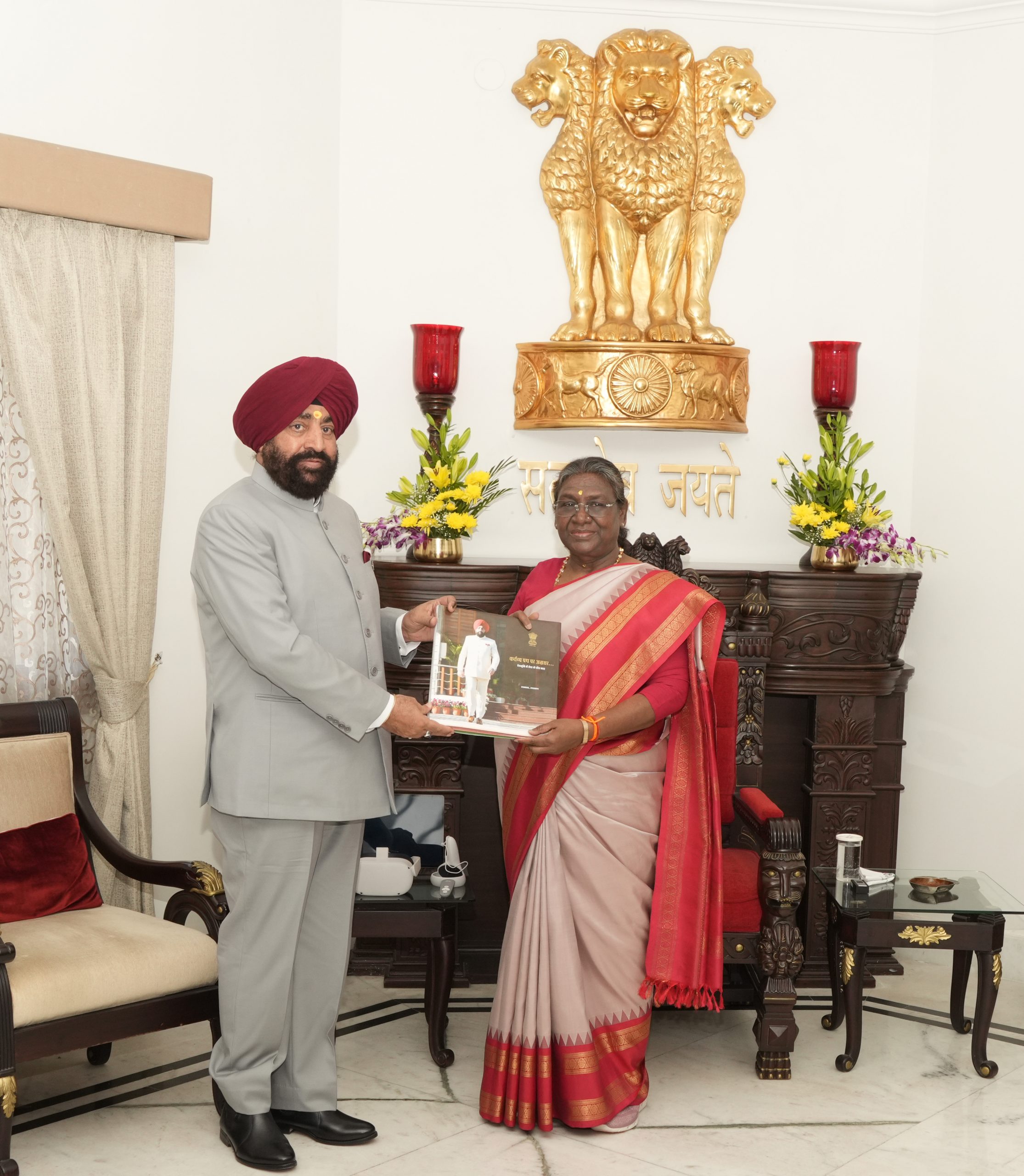 The Governor presenting a coffee table book to Hon'ble President.