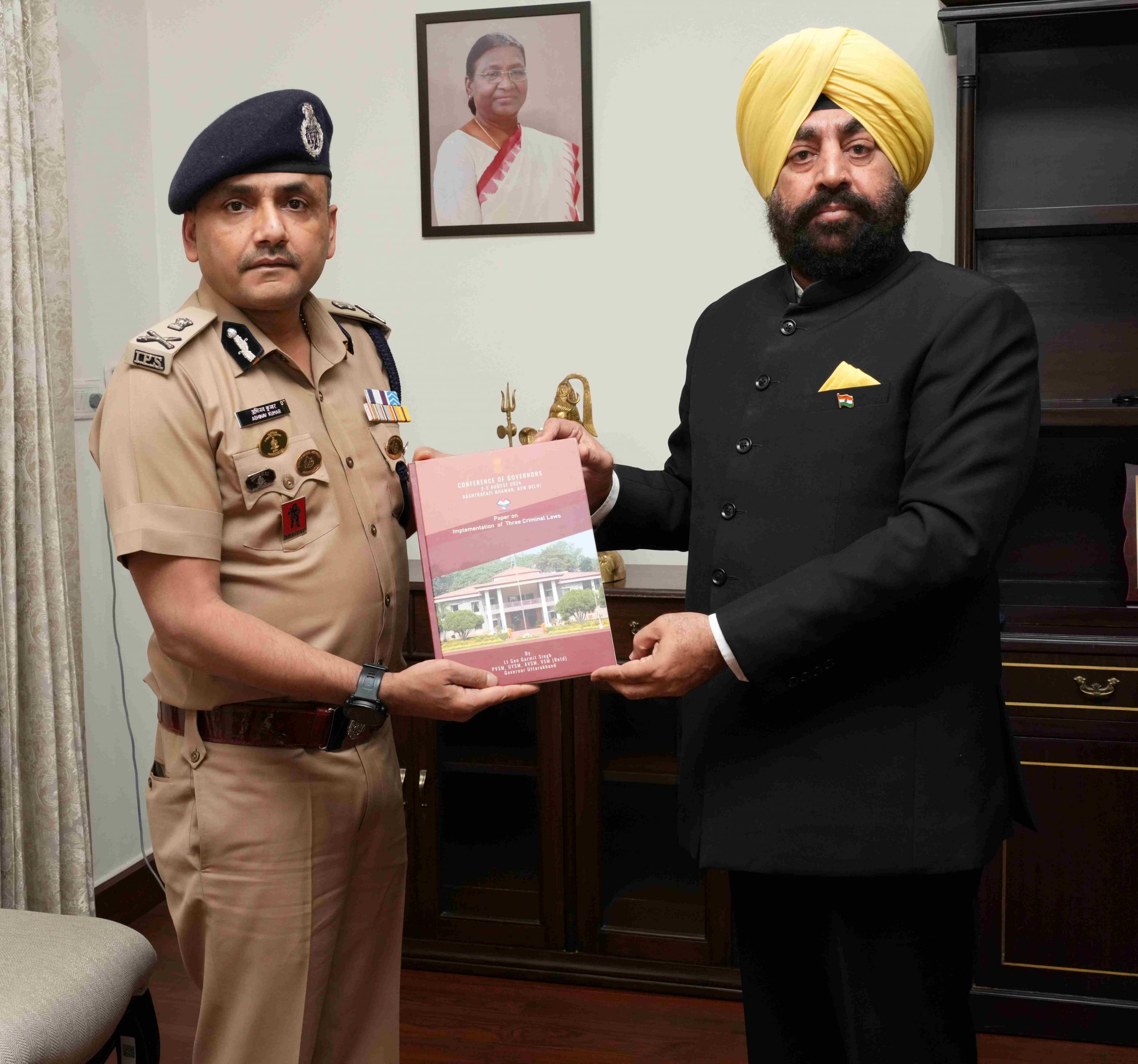 Hon'ble Governor presenting a book to DGP Shri. Abhinav Kumar.