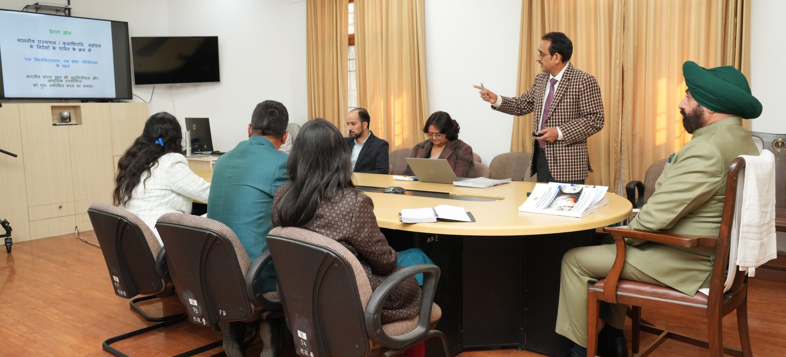 Vice Chancellor of Sridev Suman Uttarakhand University Prof. N.K. Joshi giving a presentation on the progress of research work under the "One University-One Research" scheme.