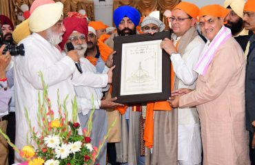 Officials of Shri Hemkund Sahib Trust presenting a memento to the Governor.