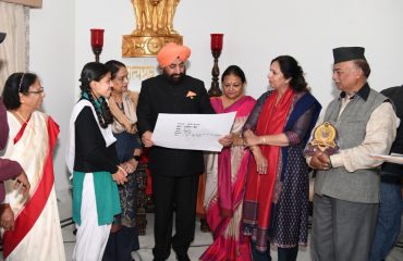 Governor Lt. Gen. Gurmit Singh (Retd.) giving prizes to the children who won the state level in the painting competition.