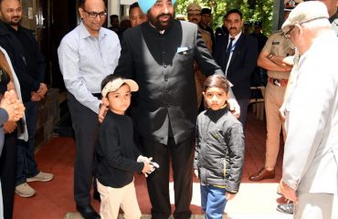 Governor interacts with two 6 year old golfers, participating in the tournament.