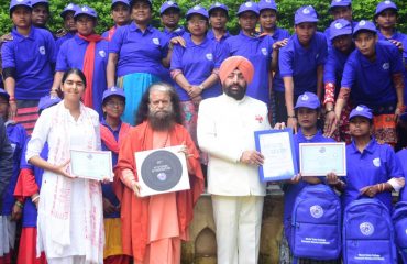 Governor Lt. Gen. Gurmit Singh (Retd) gives out citation and hygiene kit to women sanitation workers, who have been trained at Parmarth Niketan.