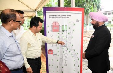 Governor Lt. Gen. Gurmit Singh (Retd) receives information about the map of the rain water conservation system.