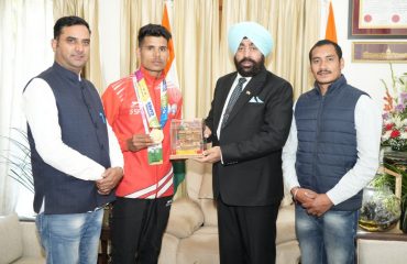 Governor Lt Gen Gurmit Singh (Retd) honors young athlete Ankit Kumar with a memento.