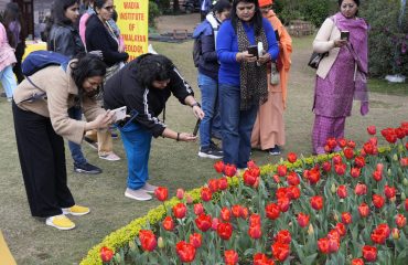 पुष्प प्रदर्शनी का अवलोकन कर फोटो खींचते हुए लोग।