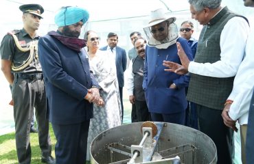 Former President and Governor observing honey processing.