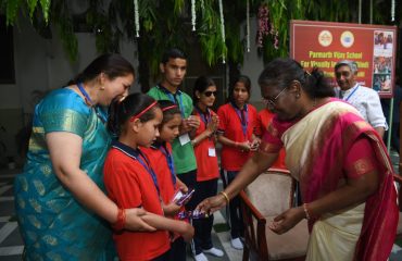 Hon'ble President Smt. Draupadi Murmu presenting gifts to children at Nari Shakti Kendra Parmarth