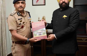 डीजीपी अभिनव कुमार को पुस्तक भेंट करते हुए राज्यपाल।
