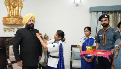 ⁠Delegation of Bharat Scouts and Guides putting a flag sticker on the Governor.