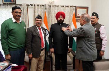 Officers of Sainik Welfare hoist the flag on the Governor, on “Armed Forces Flag Day”.