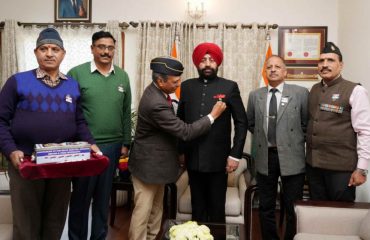 Officers of Sainik Welfare hoist the flag on the Governor, on “Armed Forces Flag Day”.