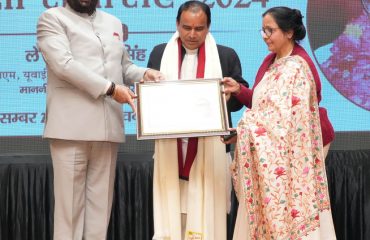 Governor honouring Cabinet Minister Dr. Dhan Singh Rawat with “Shri Nityanand Swami Swachh Rajnitik Samman” at the event.