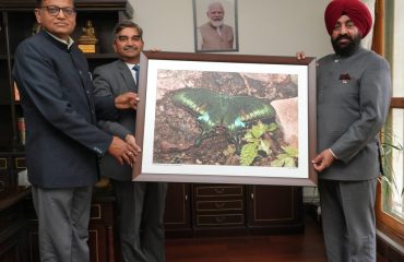 Forest department officials presenting a butterfly photo frame to the Governor.