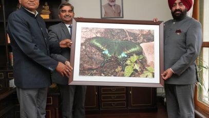 Forest department officials presenting a butterfly photo frame to the Governor.