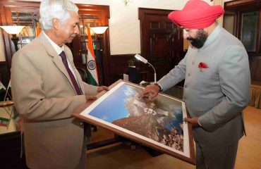 Famous cinematographer and nature lover Padma Shri Anup Shah presenting a photo frame to the Governor.