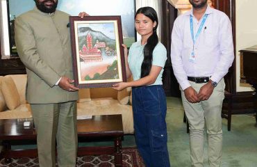 Girl from SOS Bal Gram, Bhimtal presenting a photo frame to the Governor.