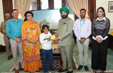 Governor presenting a gift to a girl from SOS Bal Gram, Bhimtal.