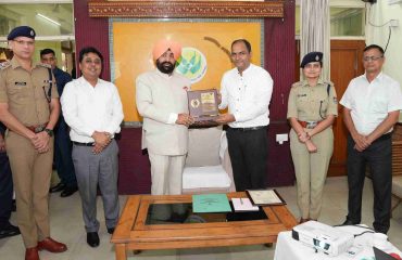 Governor felicitating Chief Development Officer Manish Kumar with a certificate and a memento for best election electoral practices.