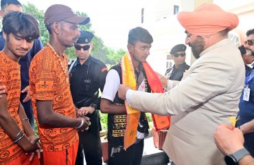 The Governor welcoming the devotees who came for the Kanwar Yatra by putting a patka and a Rudraksha garland on them.