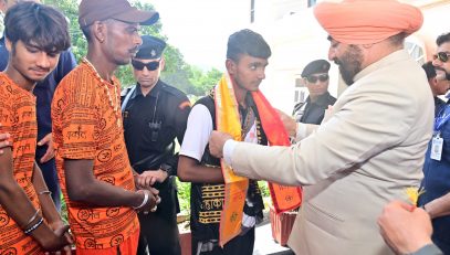 The Governor welcoming the devotees who came for the Kanwar Yatra by putting a patka and a Rudraksha garland on them.