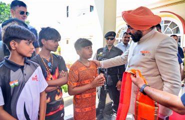 The Governor welcoming the devotees who came for the Kanwar Yatra by putting a patka and a Rudraksha garland on them.