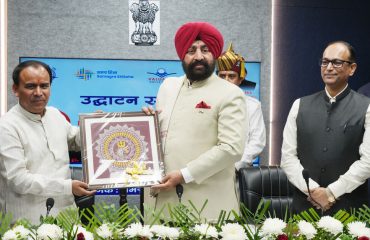 Dr. Dhan Singh Rawat presenting a memento to the Governor.