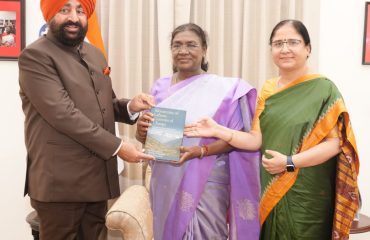 Governor presenting the book “Mountains of Labour; Currents of Change – Women's Livelihood and Economic Transitions in the Himalayan Region and Uttarakhand” to the President.