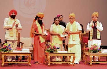 Chancellor of Patanjali University, Haridwar, Swami Ramdev, Vice Chancellor Acharya Balkrishna presenting memento and shawl to President Smt. Draupadi Murmu.