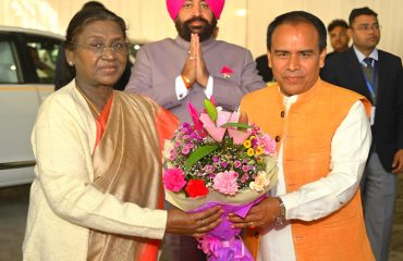 Cabinet Minister Dr. Dhan Singh Rawat welcoming President Smt. Draupadi Murmu by presenting her a bouquet of flowers on her arrival at Kainchi Dham, Baba Neeb Karori Dham.