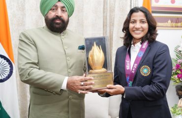 Governor presenting a memento to cricketer Sneh Rana.