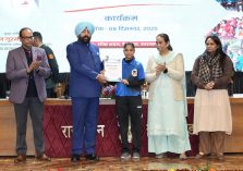 The Governor honoring a female student for her outstanding performance;?>