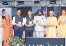 07 (1)ऋषिकेश में आयोजित अन्तर्राष्ट्रीय योग महोत्सव-2026 के समापन कार्यक्रम के अवसर पर पुस्तक का विमोचन करते हुए राज्यपाल।