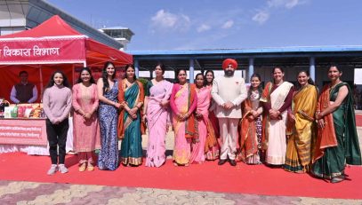 During his visit to Pithoragarh, the Governor observes and gathers information at various stalls set up by women from Self-Help Groups within the Naini-Saini Airport complex.