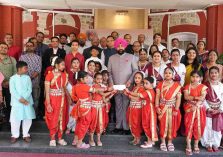 The Governor presenting cheques to young girls on the occasion of the program held at Lok Bhavan to celebrate the State Foundation Days of Rajasthan and Odisha.