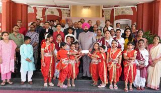 The Governor presenting cheques to young girls on the occasion of the program held at Lok Bhavan to celebrate the State Foundation Days of Rajasthan and Odisha.