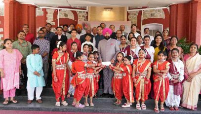 The Governor presenting cheques to young girls on the occasion of the program held at Lok Bhavan to celebrate the State Foundation Days of Rajasthan and Odisha.